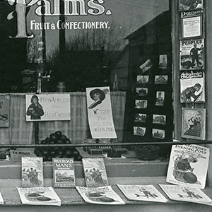 Detail of the "Palm's" store window showing postcards on display. [2015.063.005]
