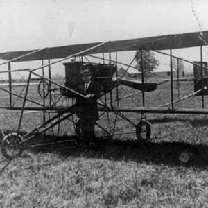 Photograph shows unidentified man posing with early biplane, reportedly first airplane in Chilliwack. Plane was brought to the Chilliwack Fair, ca. 1912 or 1913. [PP501061]