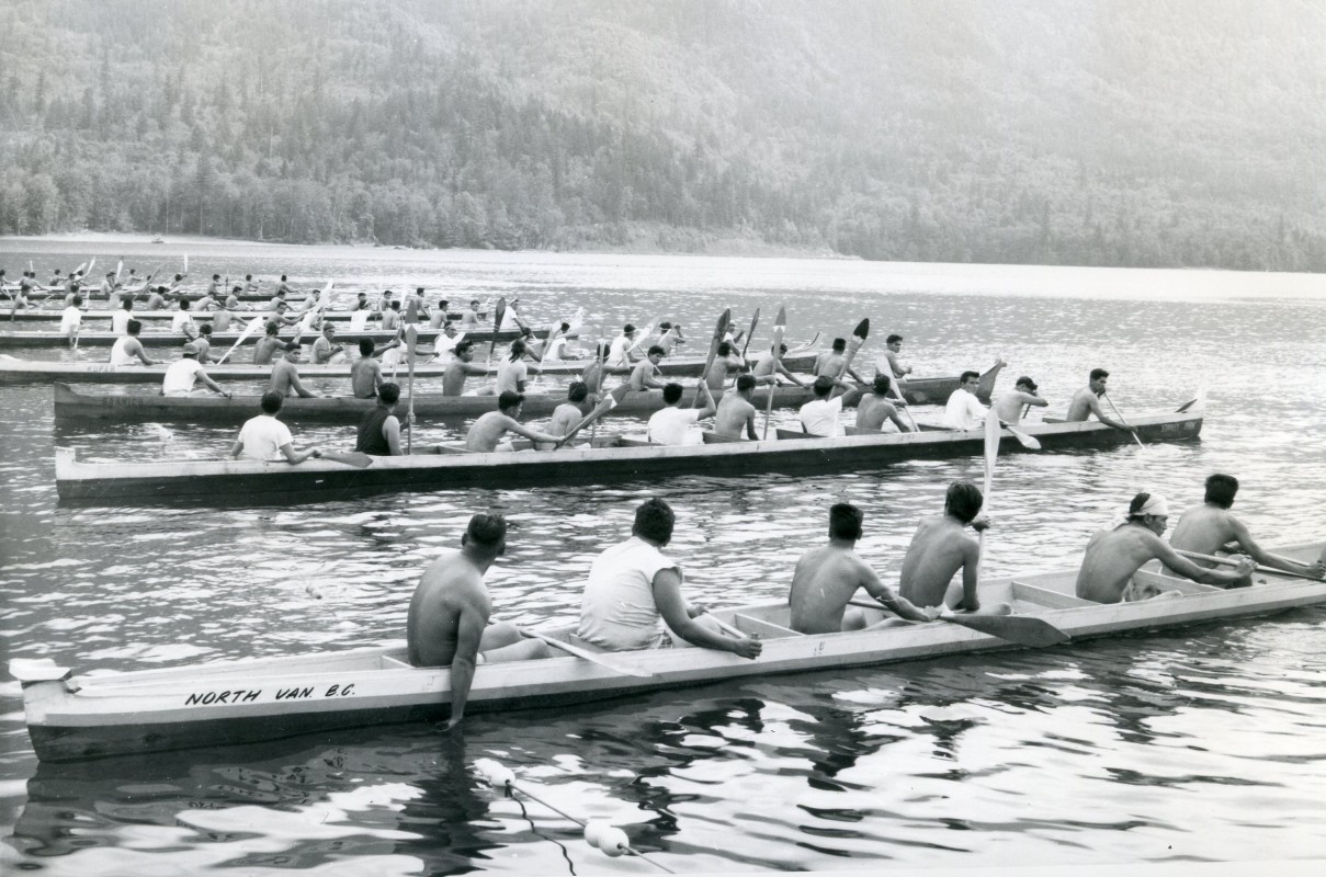 Chilliwack Progress Press Image: Image not published in newspaper.  Photograph depicts a group of war canoe race teams lined up at Cultus Lake, 1 June 1963. [1999.029.035.001]